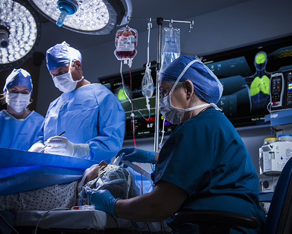 Medici che intervengono su un paziente con UniView sullo sfondo della sala operatoria