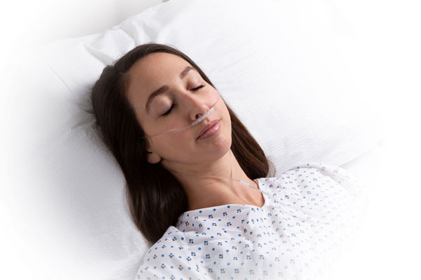 Masimo - Donna adulta in un letto ospedaliero con linea per capnografia NomoLine RRc