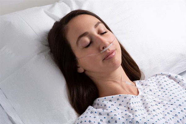 Masimo – Femme adulte dans un lit d’hôpital avec la gamme Capnographie RRc de Nomoline